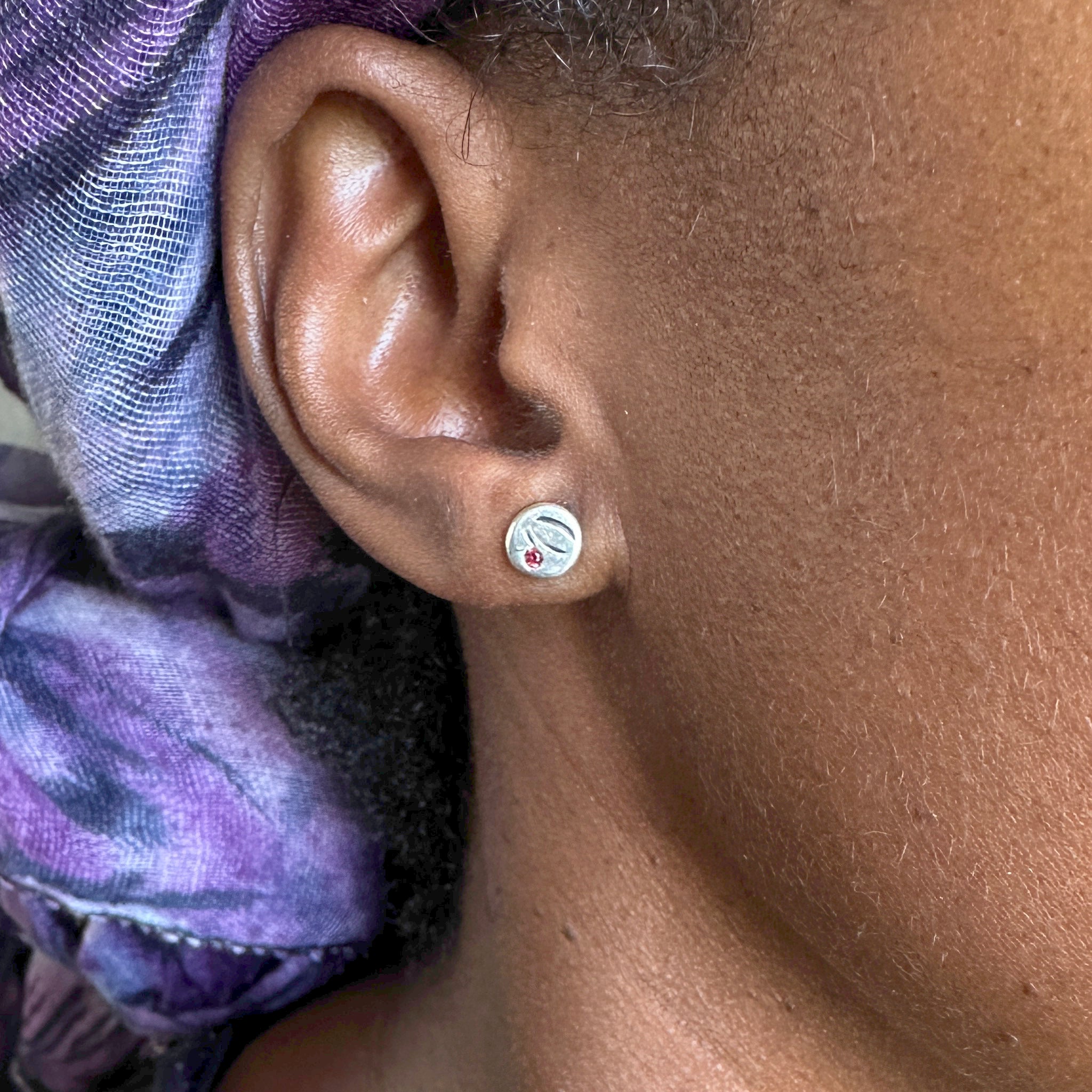 "Femme portant les boucles d'oreilles Bintou EMIKemi - puces argent et grenat"